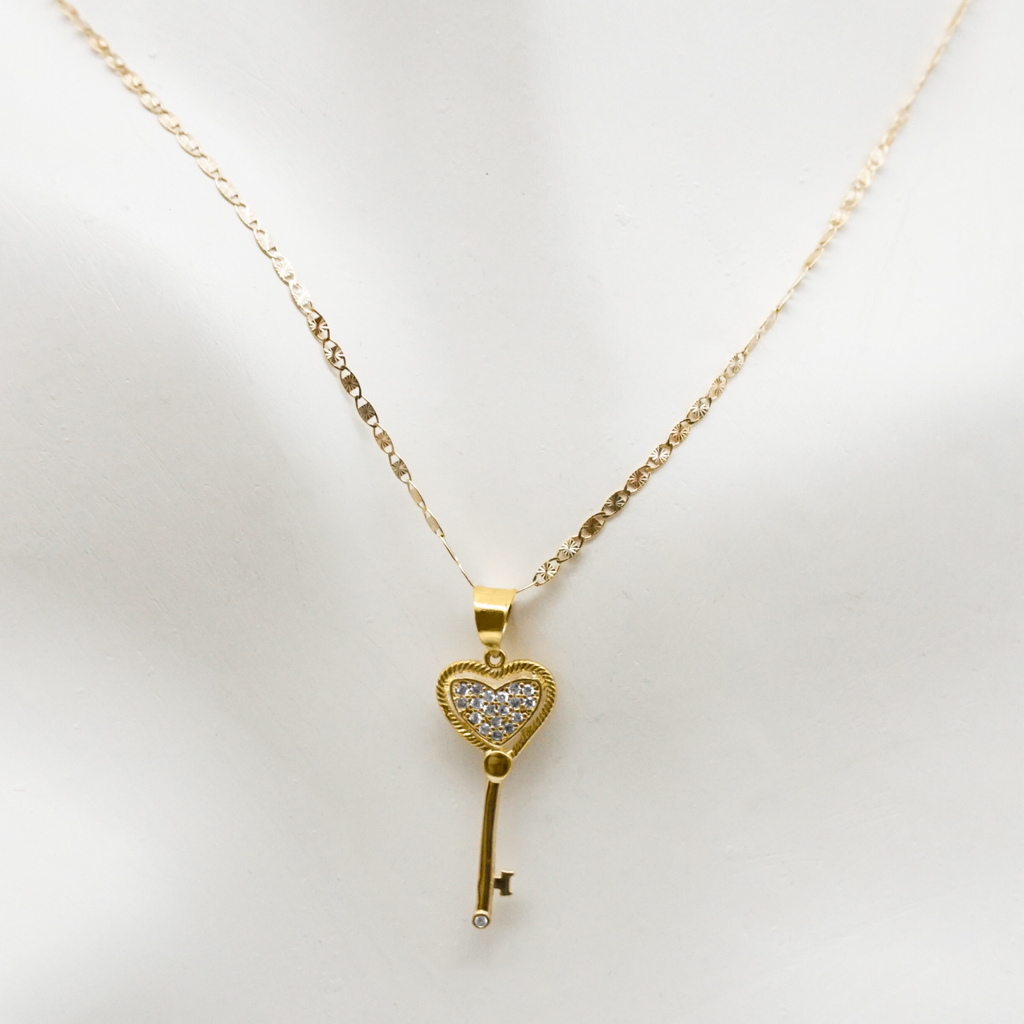 Dije en forma de llave y de oro amarillo 10k con zirconias y cadena de 3 oros